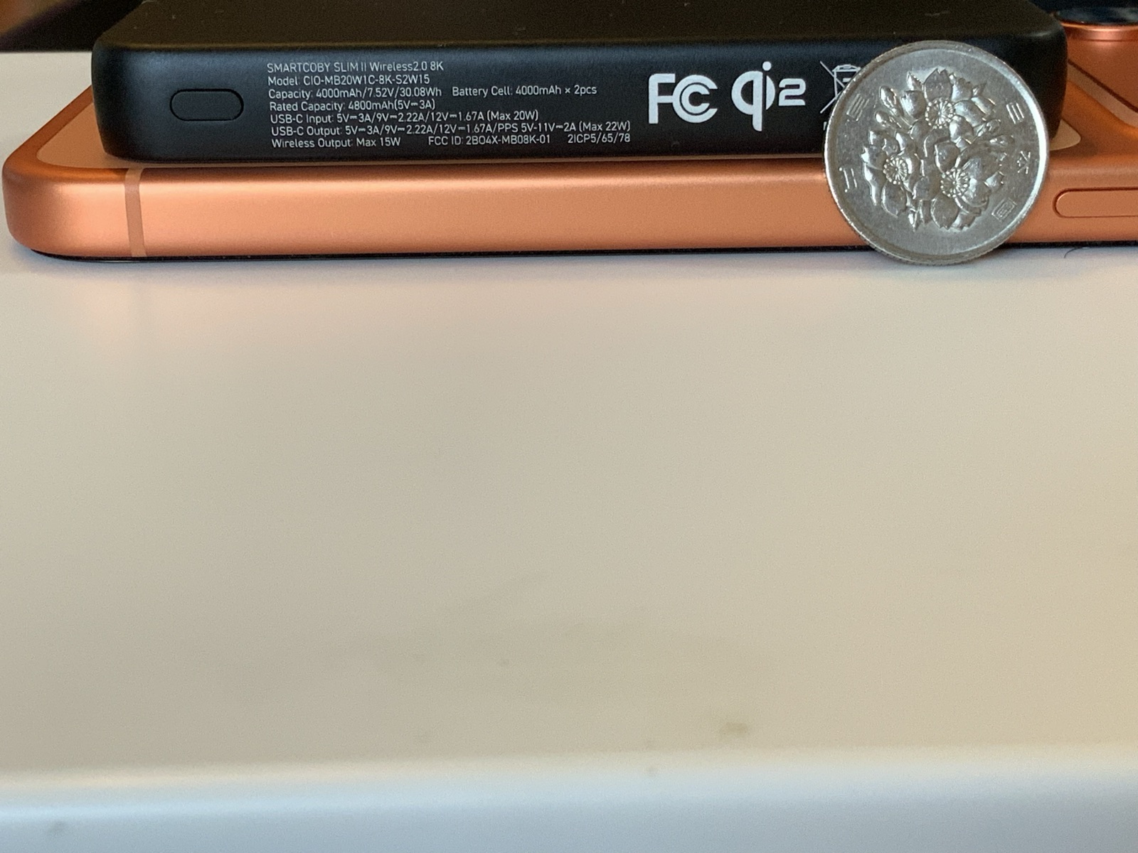 Qi2対応モバイルバッテリーをスマートフォンにマグネット装着した状態の接写。側面ラベルに30.08Wh表記