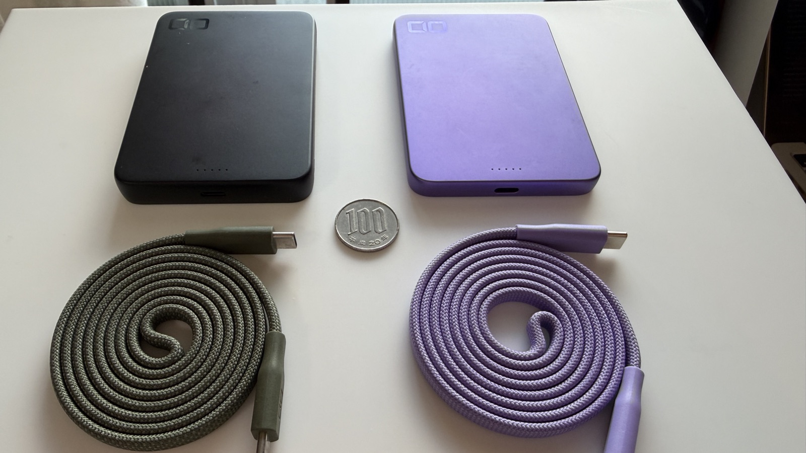 CIO SMARTCOBY SLIM II 8K(黒)とSS5K(パープル)を100円玉・フラットケーブルと並べたサイズ比較
